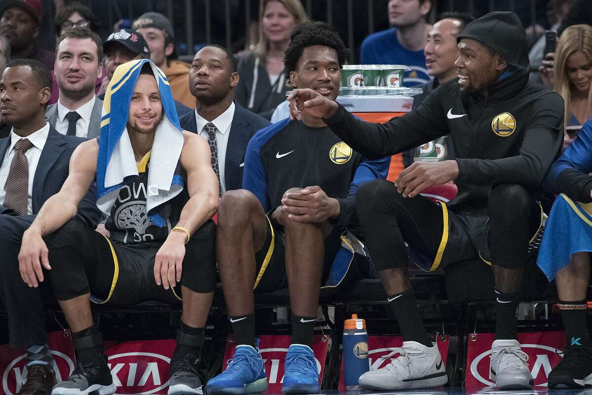 Golden State Warriors guard Stephen Curry, left, and forward Kevin Durant, right react while watching the game action from the bench during the second half of an NBA basketball game against the New York Knicks, Friday, Oct. 26, 2018, at Madison Square Garden in New York. The Warrior won 128-100. (AP Photo/Mary Altaffer)