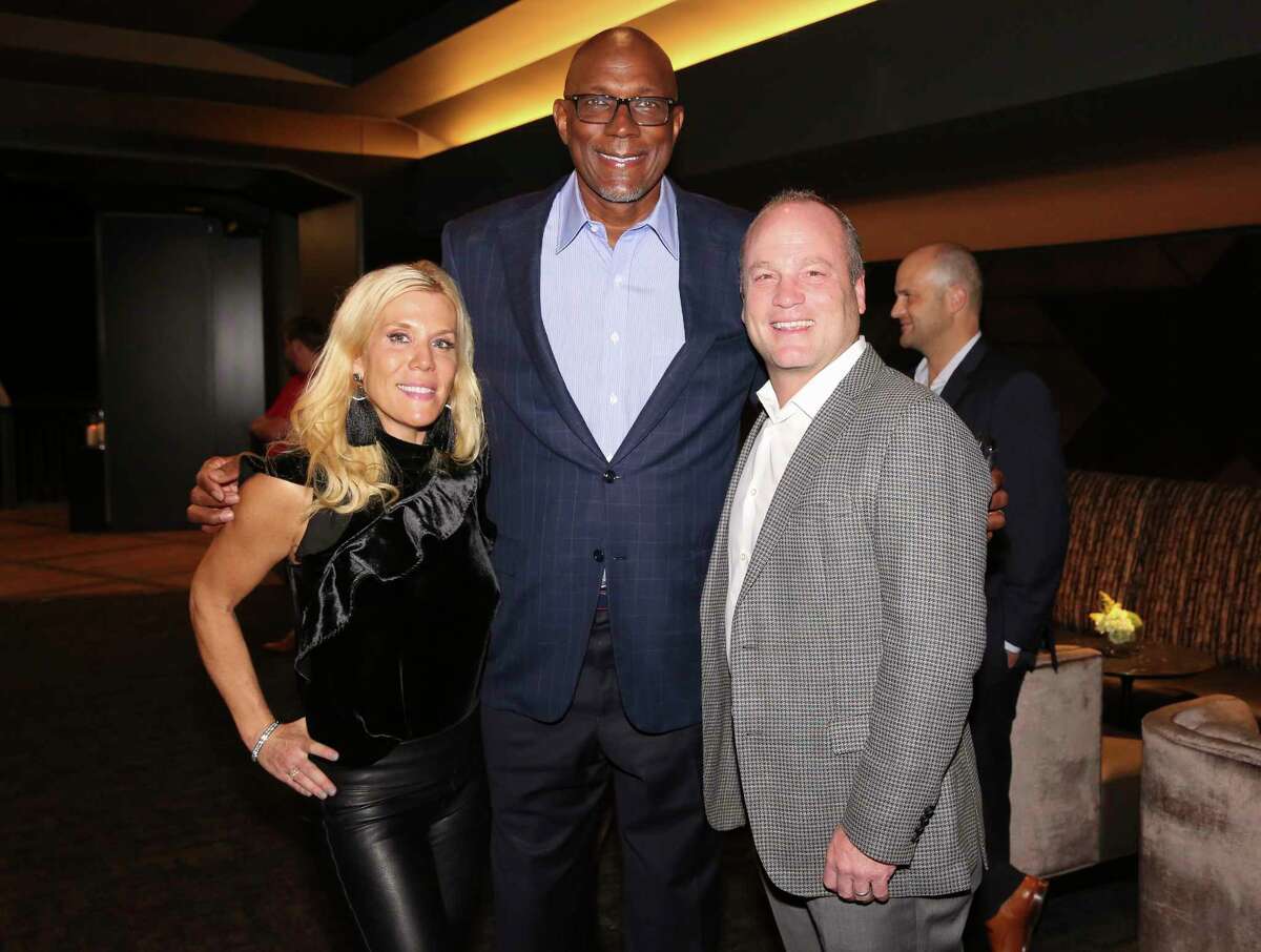 Deneise and Derek Dooley pose for a photograph with former Houston Rockets player Clyde Drexler at the Lexus Lounge before the MVPs courtside dinner, hosted by Houston Rockets and Children's Memorial Hermann, at Toyota Center on Thursday, Oct. 25, 2018, in Houston.
