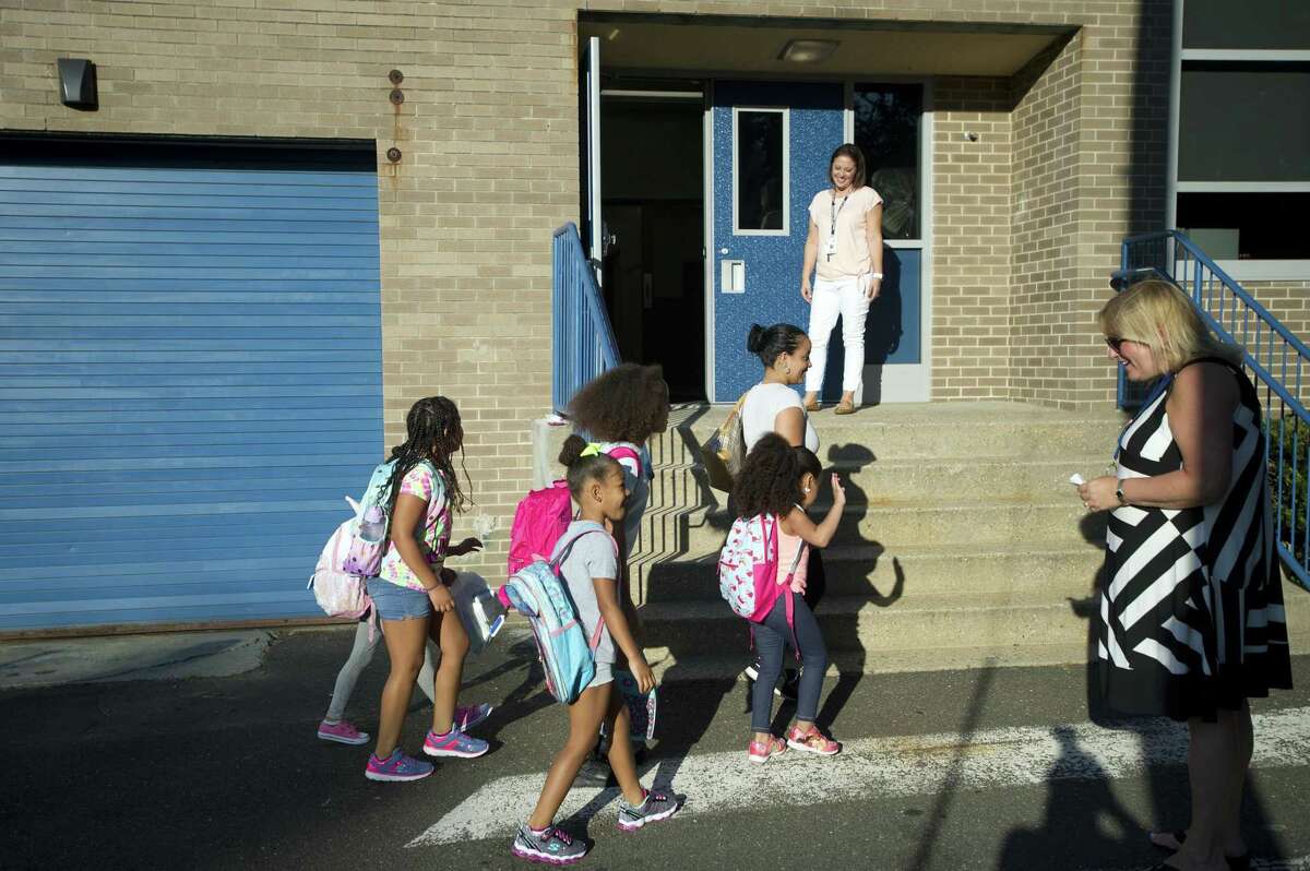 Students walk into Northeast Elementary School for the first time after summer recess in Stamford, Conn. on Thursday, Aug. 30, 2018.