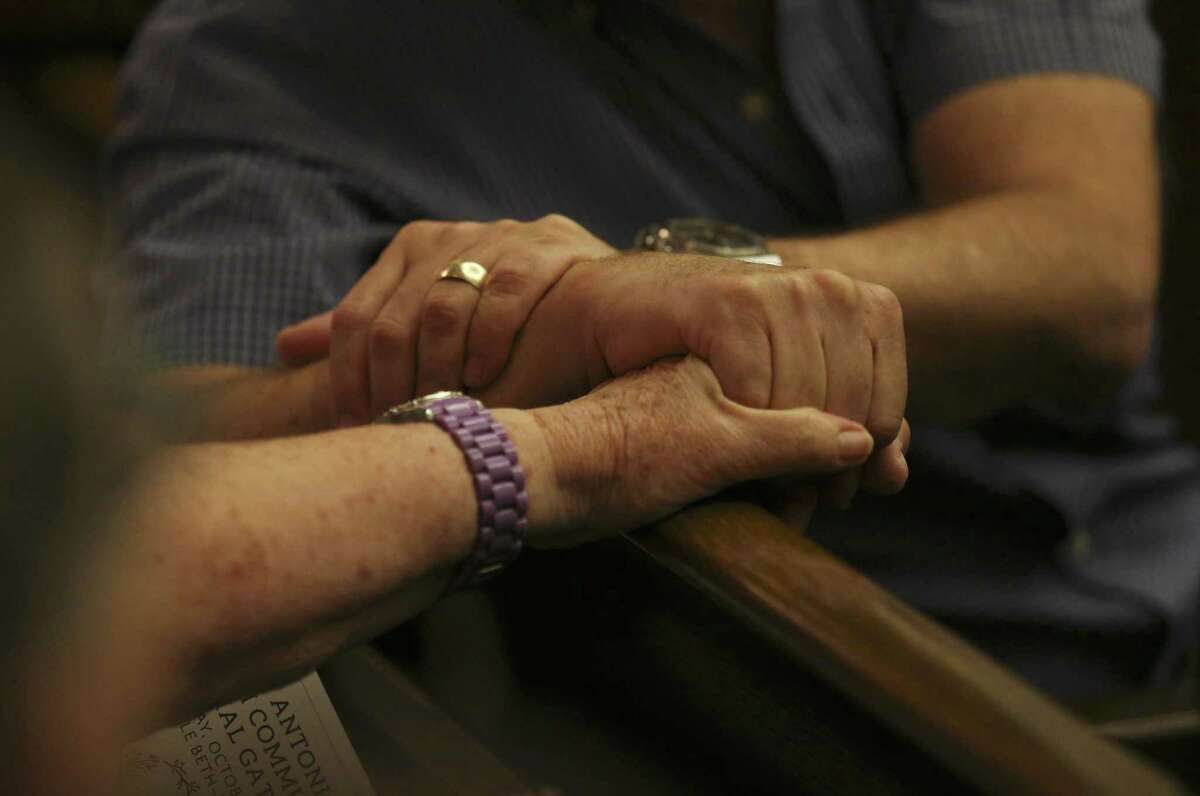 Hands from two people are clasped as Temple Beth-El hosts a memorial in the wake of last weekend's shooting deaths in a Pittsburgh synagogue on Tuesday, Oct. 30, 2018. People from all walks of faith and from the city gathered as the first funerals took place for the 11 Jewish congregants who were gunned down by a deranged anti-semite at the Tree of Life synagogue in Pittsburgh. The San Antonio Jewish community gathered at Temple Beth-El and opened their place of worship to the public to mourn the victims. (Kin Man Hui/San Antonio Express-News)