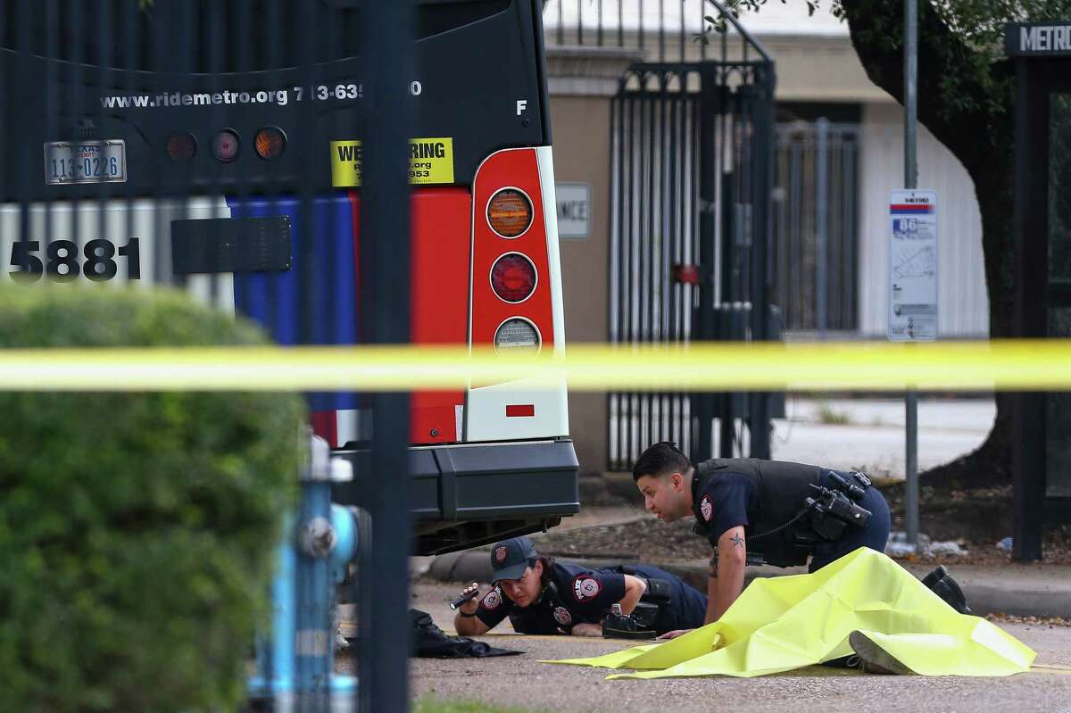 Metro police officers investigate the scene where a woman was fatally struck by a Metro bus on Peakwood Drive near Red Oak Drive Wednesday, Oct. 31, 2018, in Houston.
