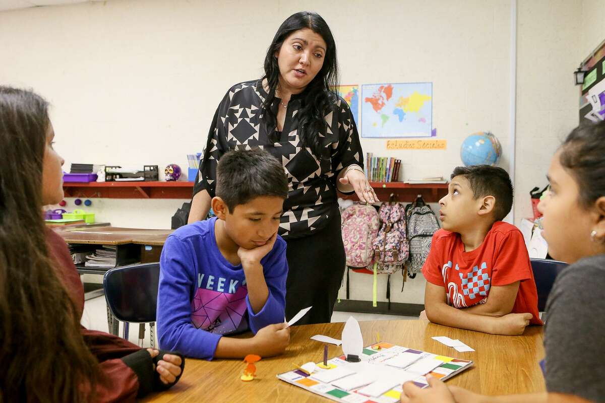 Gloria Galvan, a bilingual fifth grade teacher at Price Elementary School, engages in a science vocabulary word game with (from left) Danna Cantu, 11, Roman Sanchez, 11, Tony Castro, 11, and Diamond Rodriguez, 10, in this 2017 file photo. MARVIN PFEIFFER/ mpfeiffer@express-news.net
