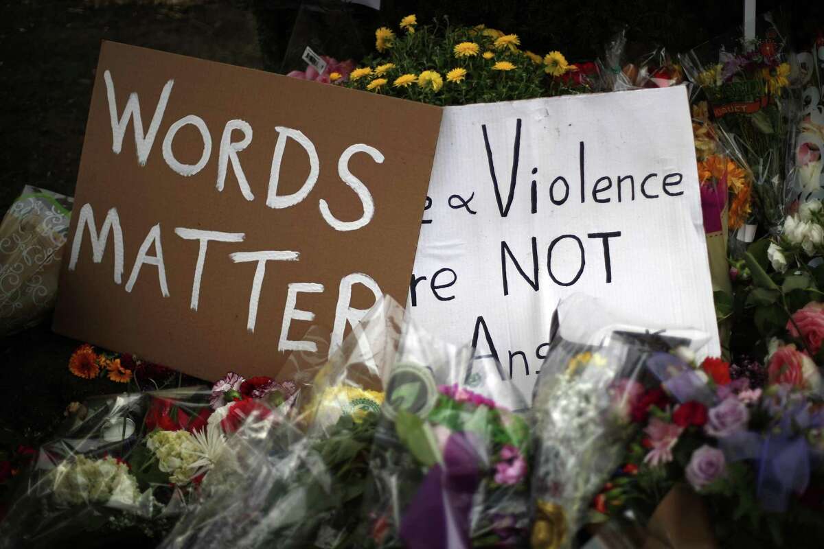 Flowers surround signs on Wednesday, Oct. 31, 2018, part of a makeshift memorial outside the Tree of Life Synagogue to the 11 people killed during worship services Saturday Oct. 27, 2018 in Pittsburgh. (AP Photo/Gene J. Puskar)