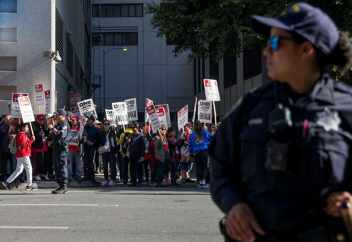 San Francisco police officers follow the crowd as hotel and hospitality workers on strike from seven different Marriott-affiliated hotels march through the streets of San Francisco, Calif. Saturday, Oct. 20, 2018.