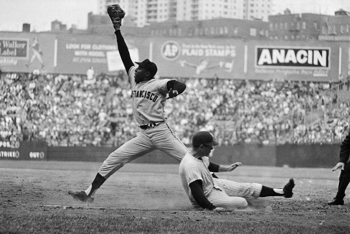 Caption: Bobby Richardson slides safely into first as Willie McCovey stretches for the late throw during game 5 of the 1962 World Series between the San Francisco Giants and New York Yankees. The Yankees defeated the Giants 4 games to 3.