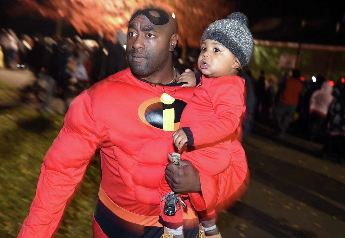 Omar Thomas of New Haven and his son, Zion, 16 months, dressed as Incredibles characters, take part in the Trunk or Treat event at Edgewood Park in New Haven on October 31, 2018.