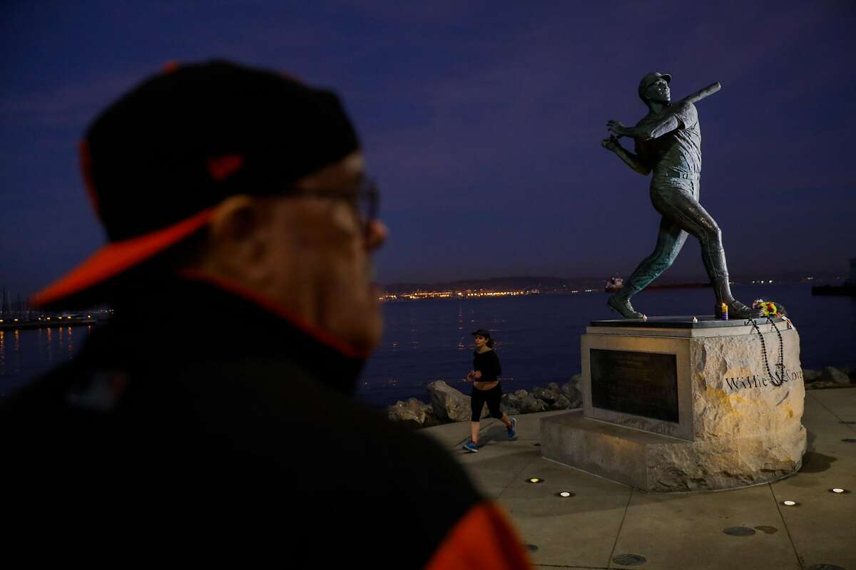 Lester Verrett (L) visits the Willie McCovey statue near AT&T park hours after the news of his death was announced in San Francisco, California, on Wednesday, Oct. 31, 2018.