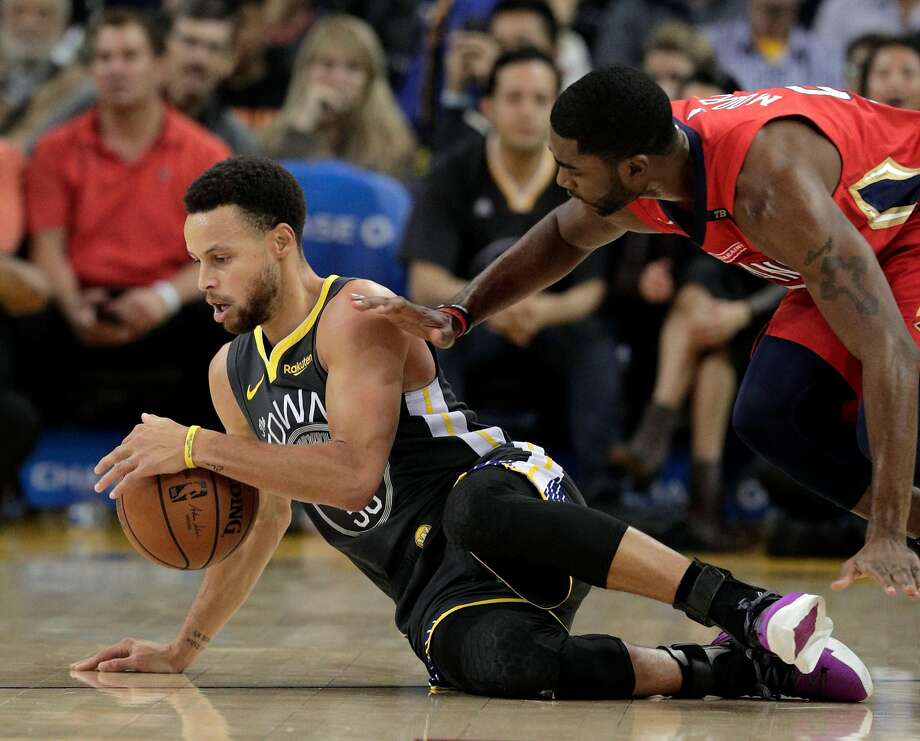 Stephen Curry scrambles for a loose ball against E’Twaun Moore. Curry finished with 37 points and nine assists. Photo: Carlos Avila Gonzalez / The Chronicle