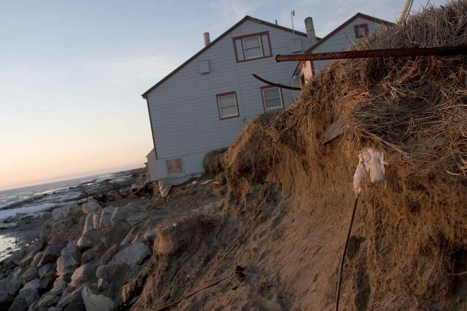 Speaking of disappearing islands: A report for the State of Alaska states, "Shishmaref is a traditional Inupiat village with a fishing and subsistence lifestyle. The community is located on Sarichef Island, a barrier island approximately one quarter mile wide and about three miles long. ... The primary erosion hazards are wave and slough erosion, sea ice gouging, and slumping resulting from melting permafrost.
"According to the local hazard mitigation plan, 'the effects of climate change are expected to add to natural hazards including flooding in coastal areas. As sea level rises and the offshore ice pack retreats, more coastal flooding can be expected.' "
Photo: A grim reminder of the power of the fall season's storms that have pounded Shishmaref's shores, left unprotected by recent climate change, the soil erosion has not been slowed by the rocks and junk deposited by the villagers around this house. Photo: Gilles Mingasson/Getty Images
