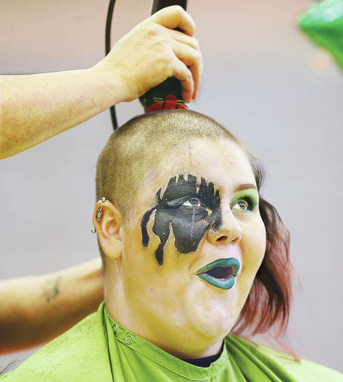 Alton High School senior Harmony Schallenberg reacts Wednesday at the school as her head is shaved during the school’s 10th annual St. Baldrick’s Foundation fundraiser for childhood cancer research. About 27 students participated this year, raising $11,000 for the charity. One student alone raised $3,100 for the cause. Students and parents gathered to watch the annual ritual in the school gymnasium. Over the past decade, Alton High School has raised more than $90,000 for cancer research. Additional photos in a slideshow at thetelegraph.com.