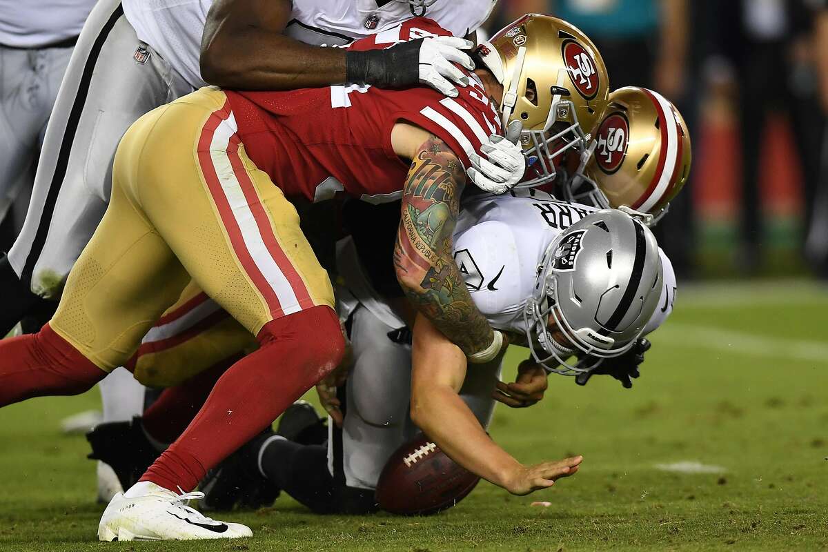 SANTA CLARA, CA - NOVEMBER 01: Derek Carr #4 of the Oakland Raiders is sacked by Cassius Marsh #54 and Dekoda Watson #97 of the San Francisco 49ers and loses the ball during their NFL game at Levi's Stadium on November 1, 2018 in Santa Clara, California. (Photo by Thearon W. Henderson/Getty Images)
