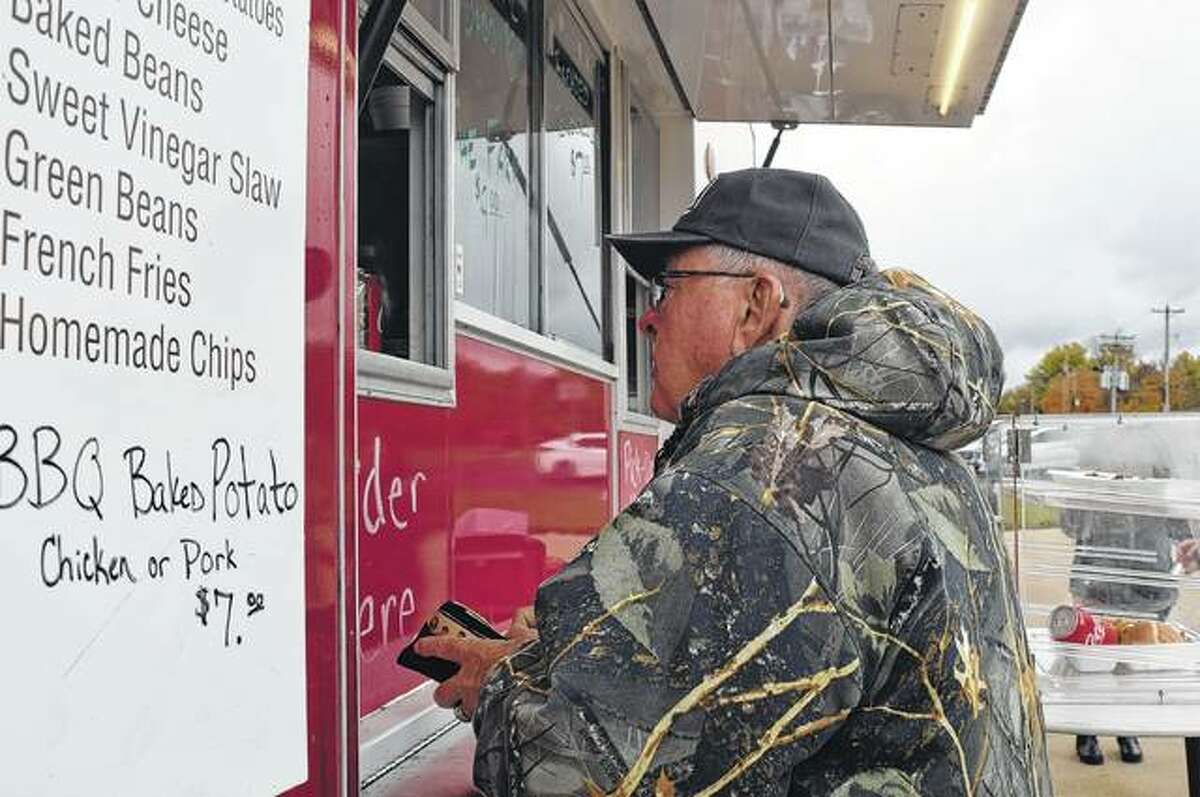 Don Pigg of Jacksonville buys a meal Thursday from Twyford’s BBQ outside Diversified Crop Insurance Services.