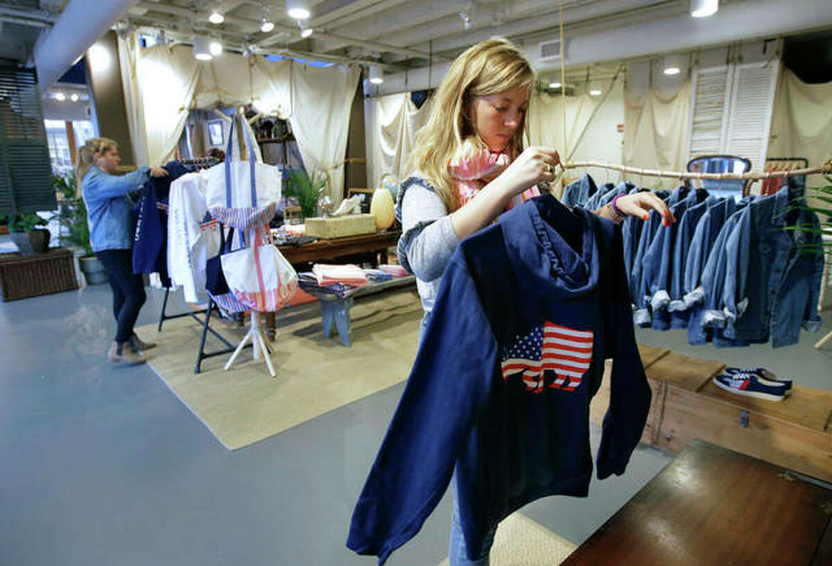 American Rhino apparel store employee Coco Clemens handles a garment at a store location. Chris Welles, owner of American Rhino, and other small business owners needing seasonal help are paying higher wages and offering bonuses as they compete with big companies for a shrinking pool of workers.