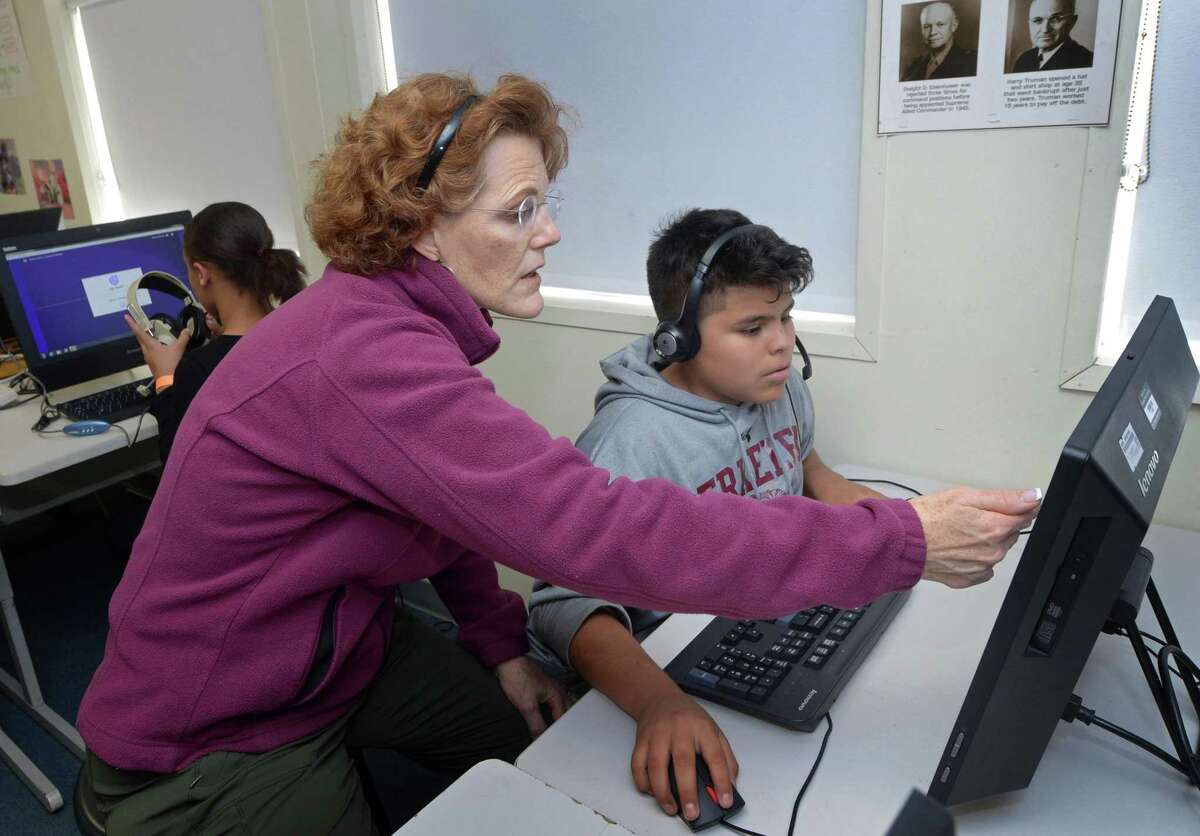 Virginia Seeley helps her student Chris Mejia follow the lesson in their individual computer rotation as part of the Read 180 program during Mrs. Seeley's 6th grade class Tuesday, October 30, 2018, at Ponus Ridge Middle School in Norwalk, Conn.