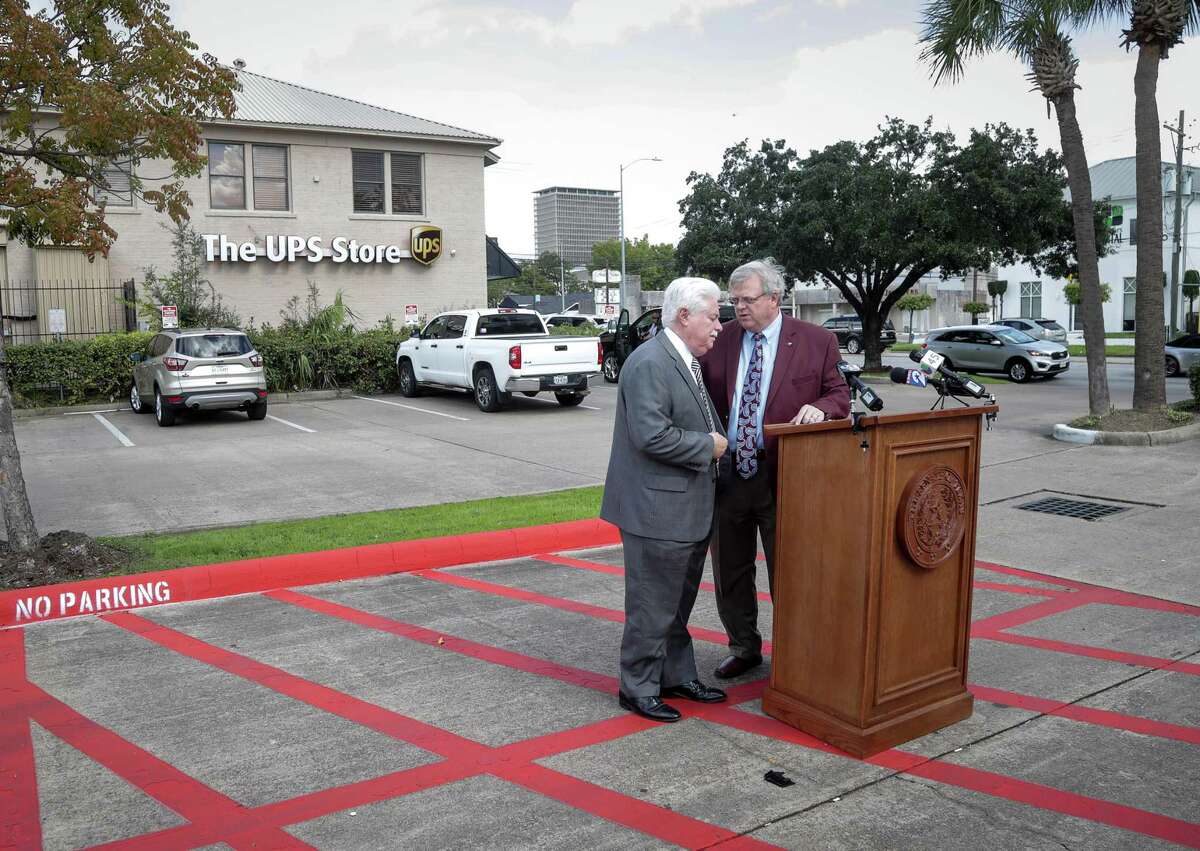 State Sen. Paul Bettencourt, right, talks with Stan Stanart, Harris County clerk, before a press conference about alleged voter registration problems, in the parking lot of a UPS store, Tuesday, Oct. 30, 2018, in Houston. Bettencourt said 84 people are registered to vote at the UPS store through post office boxes.
