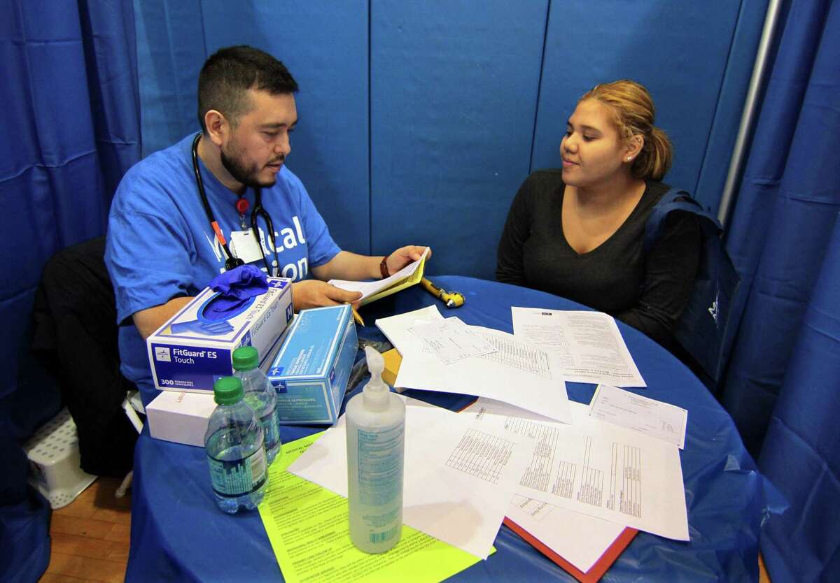 Dr. Jose Mejia goes over the medical history of patient Melissa Medina, of Bridgeport, during St. Vincent?’s fourth annual Medical Mission at Home at Cesar Batalla School in Bridgeport, Conn., on Saturday, Nov. 3, 2018. More than 300 volunteers helped to provide free medical care to members of the community. Some of the free services provided for adults includes medical exams, vaccinations, podiatry services, haircuts, food provided by the Connecticut Food Band as well as shoes and coats.