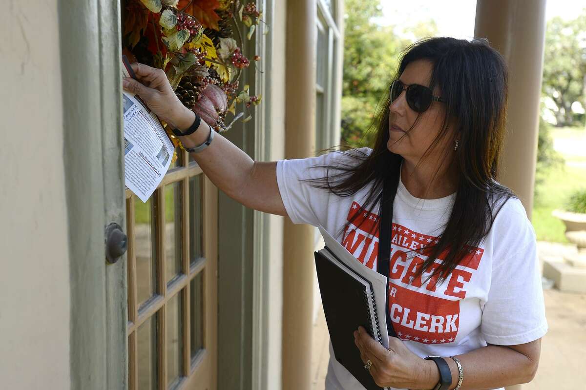 Rhonda Lomonte leaves information on a door while campaigning for the Jefferson County Republican Party on Saturday. Photo taken Saturday 11/3/18 Ryan Pelham/The Enterprise
