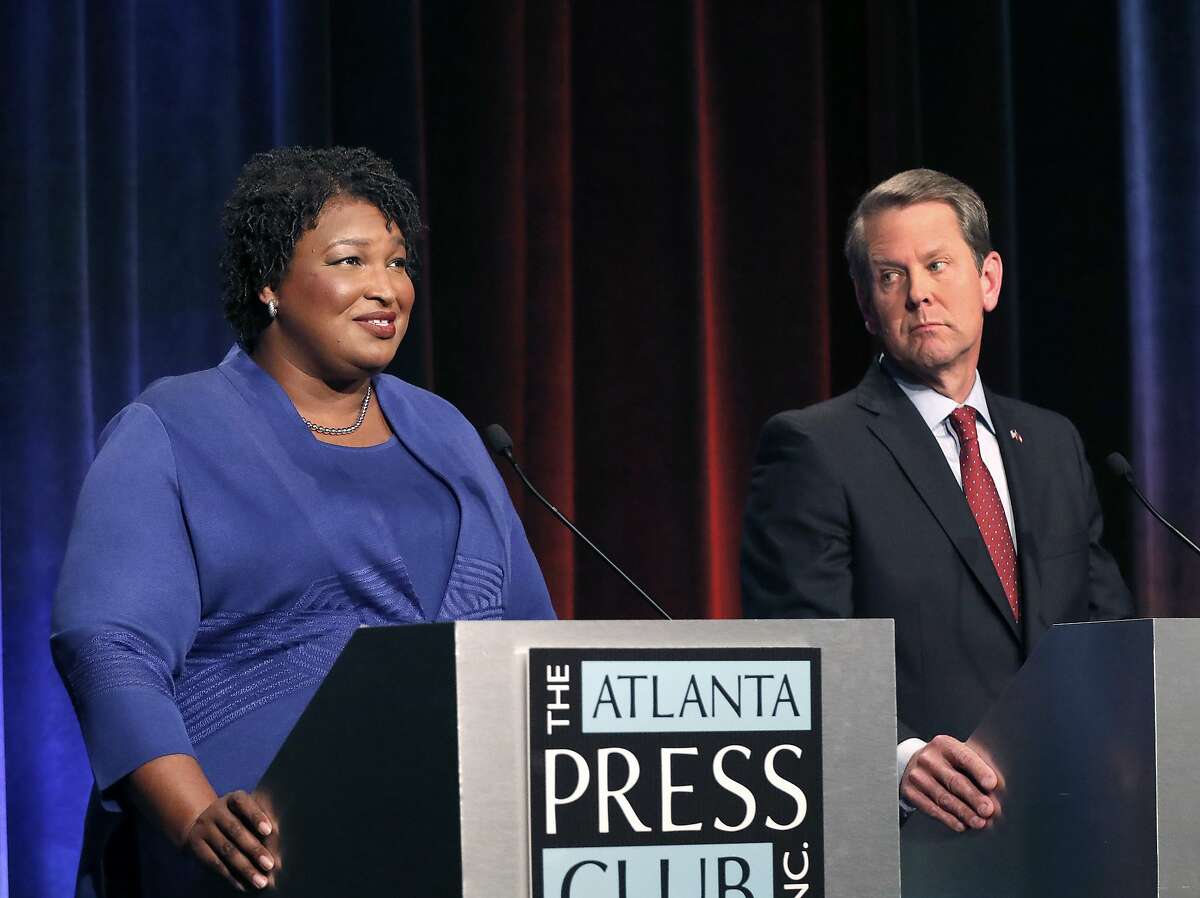 FILE - In this Tuesday, Oct. 23, 2018 file photo, Democratic gubernatorial candidate for Georgia Stacey Abrams, left, speaks as her Republican opponent Secretary of State Brian Kemp looks on during a debate in Atlanta. This year's midterms seem to be unlike any other that has happened before it, with key issues dividing voters.