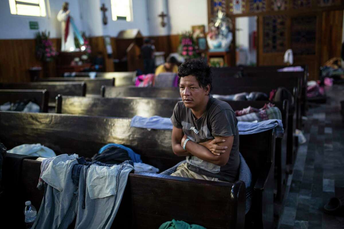 A Central American migrant wakes up inside a church that opened its doors to members of a caravan who splintered off the main group in order to reach the capital faster, in Puebla, Mexico, Sunday, Nov. 4, 2018. Thousands of wary Central American migrants resumed their push toward the United States on Sunday, a day after arguments over the path ahead saw some travelers splinter away from the main caravan, which is entering a treacherous part of its journey through Mexico. (AP Photo/Rodrigo Abd)