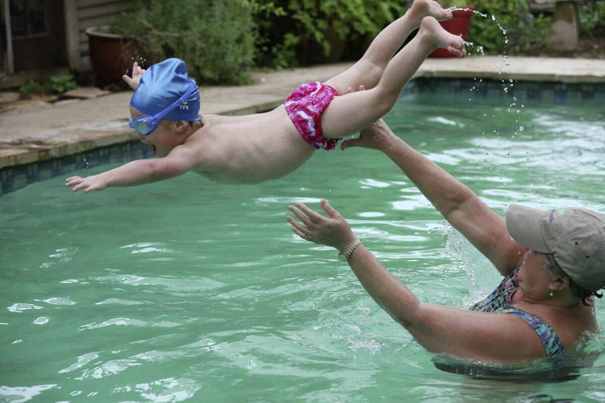Diana Perry tosses three-year-old Teddy Berios during swimming lessons at her house, Tuesday, Oct. 23, 2018. Perry is the founder of Good Swim, a program that teaches special needs children. She has been a swimming instructor for 30 years.