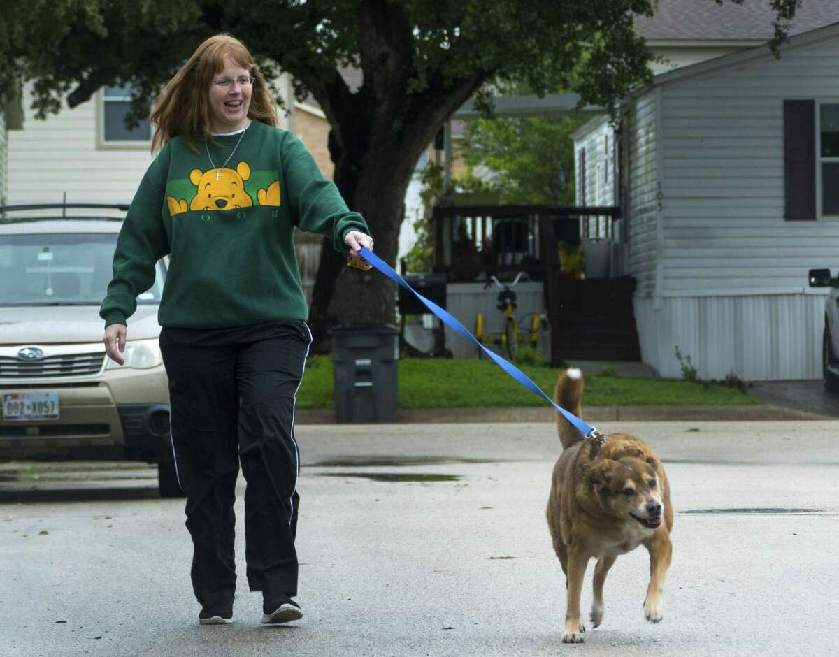 Jennifer Nelms, a cancer survivor who depends on an opioid to function, walks her dog, Priscilla, on Tuesday, Oct. 16, 2018. She said that her dog first sensed her cancer.