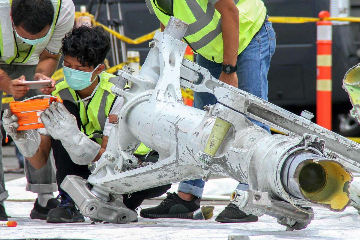 Lion Air investigators examine part of the landing gear of the ill-fated Lion Air flight JT 610 at the port in northern Jakarta on November 5, 2018. - The Boeing 737 Max 8 with 189 people plunged into the Java Sea just 12 minutes after takeoff on a routine one-hour flight from Jakarta to Pangkal Pinang city in Sumatra on October 29. (Photo by AZWAR IPANK / AFP)AZWAR IPANK/AFP/Getty Images