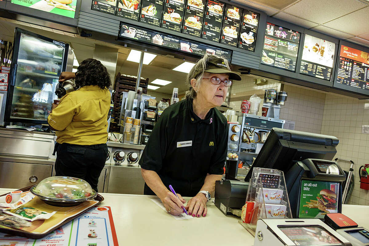 A senior woman working in a McDonald's restaurant. Seniors are replacing teenage employees at many fast food establishments.