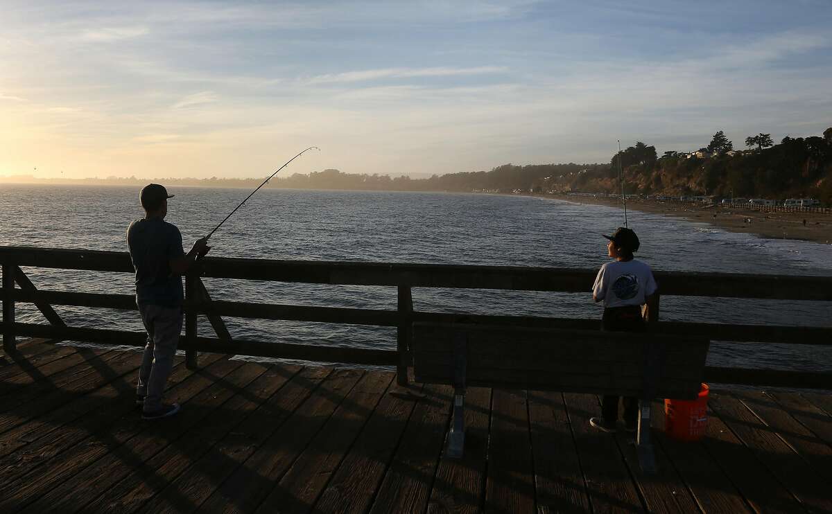 Fishermen try their luck on a fishing pier at Seacliff Beach near the remains of the S.S. Palo Alto on Friday, 11/02, 2018 in Aptos, California. "The Cement Boat" was built as an oil tanker and launched in 1919 and was later purchased by an amusement company and towed to Seacliff State Beach in Aptos where it was grounded in the bay and connected to the shore by a long pier. An arcade, dining room, dance hall and even a swimming pool were built on the ship. After being partially destroyed in a storm, it was turned into a fishing pier.