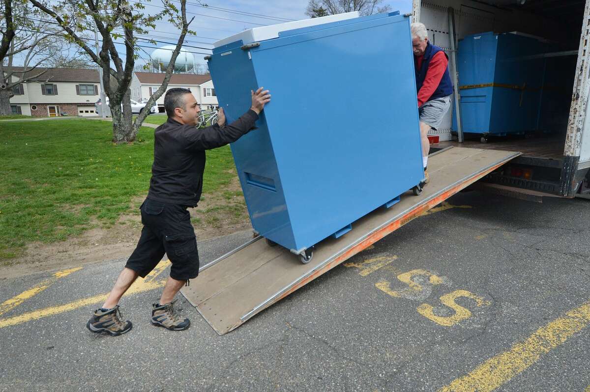 Angelo Greco and Rich Bartlett roll a cabinet from a truck containing ballots, tabulators and voting items into the polling place at Nathan Hale School in Norwalk. Conn. The polls will be open on Tuesday, Nov. 6, 2018, from 6 a.m. to 8 p.m.