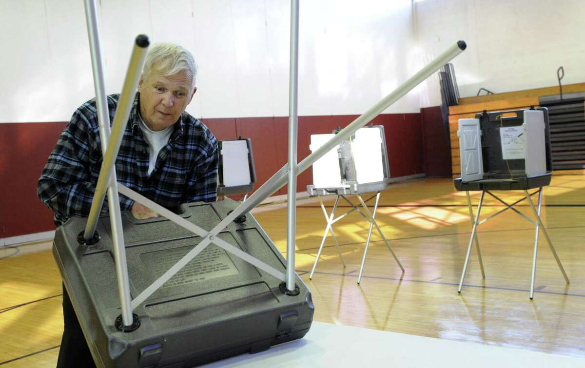 A town worker sets up voting tables at the Bethel Municipal Center polling place in Bethel, Conn. Polls will be open on Tuesday, Nov. 6, 2018, from 6 a.m. to 8 p.m.