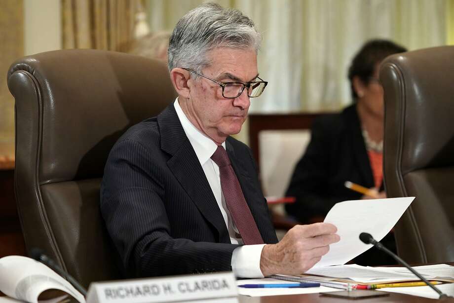 Fed President Jerome Powell reviews the newspapers at a meeting of the US Federal Reserve last week. Photo: Jacquelyn Martin / Associated Press