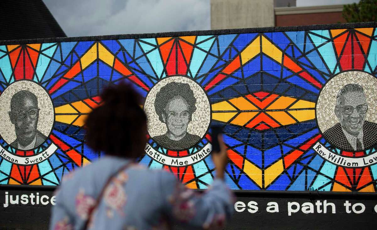 A woman photographs the new mural The Sacred Struggles / Vibrant Justice Mural along the Columbia Tap trail behind the Pilgrim Congregational United Church of Christ, Monday, Nov. 5, 2018 in Houston. The mural pays tribute to eight of Houston's African American civil rights leaders.