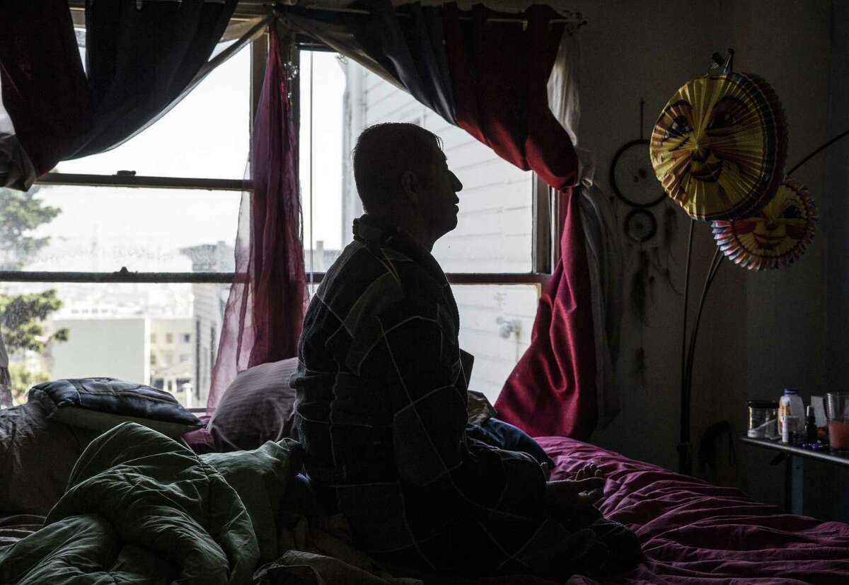 Jesus Guillen, a longterm HIV survivor, takes a moment to meditate in his bedroom before starting his day in San Francisco on Thursday, October 18, 2018.