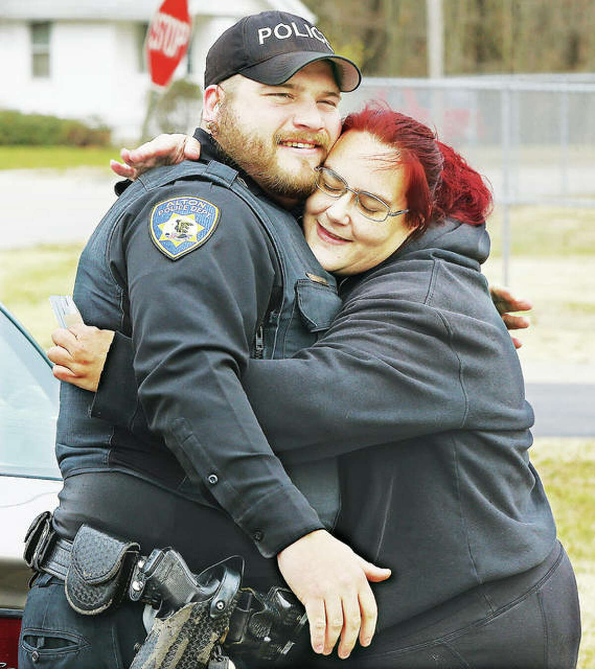 Angela Anderson of East Alton gives a big hug to Alton police officer Pfc. Elliott Fergurson Thursday after getting a $50 gift card to Aldi during last year’s “Summons of Joy” giveaway. The Alton Police Department will once again be raising money for a good cause with a “No Shave November” campaign this month.