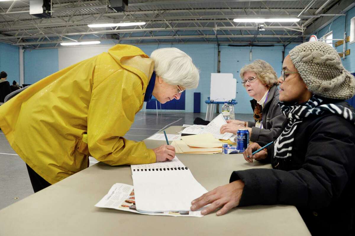 Susan DuBois, left, signs in to vote with election inspectors Wendy Lindskoog and Joanna Puertas, right, at the Parks & Recreation Department Tuesday Nov. 6, 2018 in Albany, NY. (John Carl D'Annibale/Times Union)
