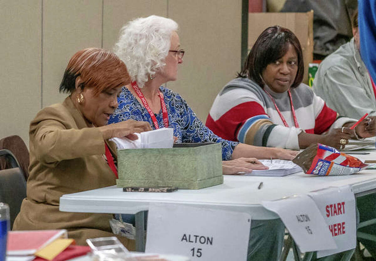 Election judges huddle Tuesday at Senior Services Plus, which served as Precinct 15 in Alton.
