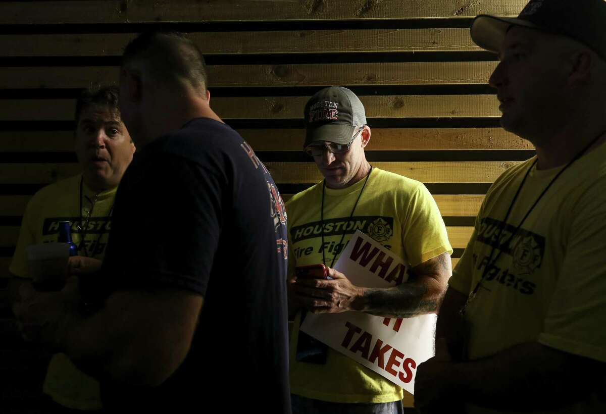 Houston Fire Department Station 45 A-shift engine operator Eric Hobbs, 45, center, checks voting results on his cellphone while attending a Prop B watch party at the White Oak Music Hall Tuesday, Nov. 6, 2018, in Houston.