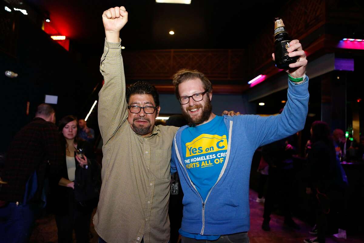 Evan Owski, a tech worker who rallied for Prop C, and Miguel Carrera, Organizer at the Coalition on Homelessness, celebrate at the Yes on C campaign watch party in the Mission District on Tuesday, November 6, 2018 in San Francisco, Calif.