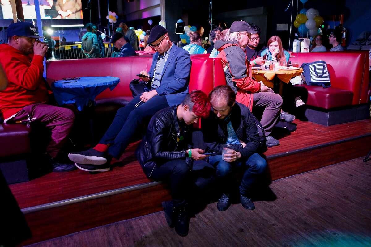 Supports check their phones for election results at the Yes on C campaign watch party in the Mission District on Tuesday, November 6, 2018 in San Francisco, Calif.