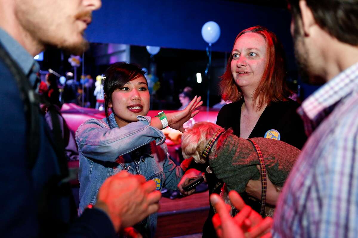 Sam Lew (L), Yes on C campiagn manager, and Christin Evans, owner of Booksmith, talk with supporters at the Yes on C campaign watch party in the Mission District on Tuesday, November 6, 2018 in San Francisco, Calif.