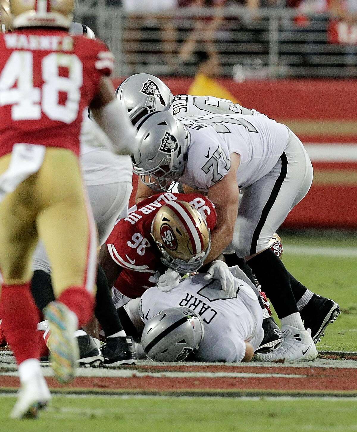 Derek Carr (4) is sacked in the second quarter as the San Francisco 49ers played the Oakland Raiders at Levi's Stadium in Santa Clara, Calif., on Thursday, November 1, 2018.