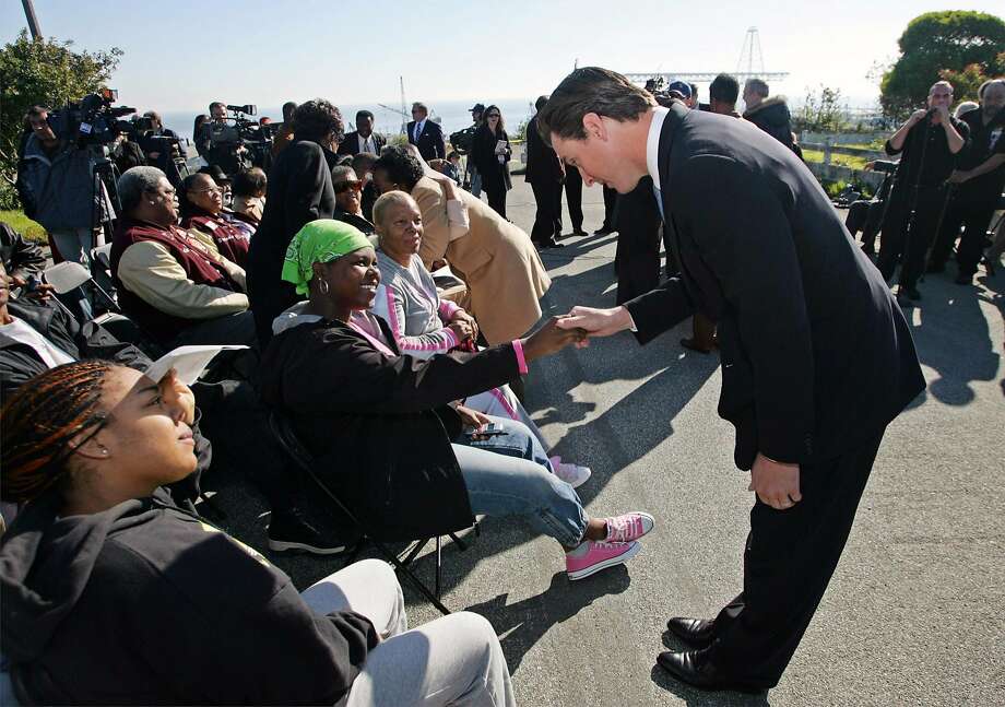 San Francisco Mayor Gavin Newsom, right, bows to members of the Bayview Hunters Point community prior to a ceremony where the Navy transferred title to the first 75 acres of the Hunters Point Shipyard in San Francisco, Wednesday Jan. 12, 2005. Since 1974 the shipyard has been closed and the land has remained unused.  The transfer will allow San Francisco and the community to move forward with a revitalization effort that includes housing, parks, and commercial venues.(AP Photo/Eric Risberg) Photo: Eric Risberg / Associated Press 2005