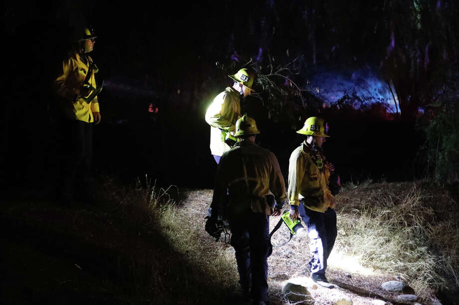 Firefighters survey the area around Borderline Bar & Grill after a shooter wounded seven Wednesday night on November 8, 2018 in Thousand Oaks, California. The gunman burst into the bar around 11:20 p.m., cloaked in all black as he threw smoke bombs and began shooting at targets as young as 18 inside the Borderline Bar & Grill, authorities and witnesses said. Photo: Al Seib/Getty Images / 2018 Los Angeles Times