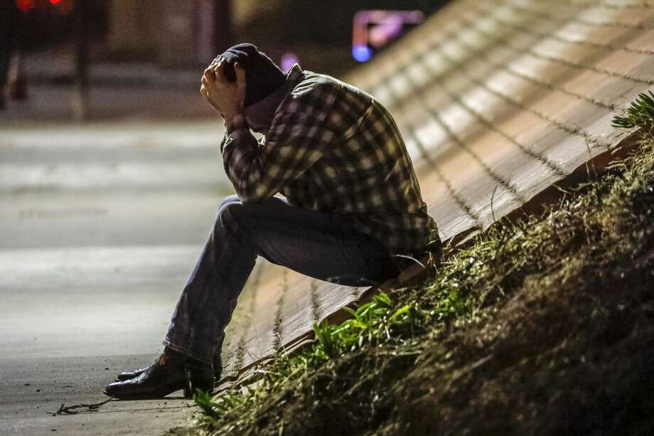 Tim Dominguez who was in the bar with his son distraught over the shooting sits under the freeway after a gunman opened fire late Wednesday at a Thousand Oaks bar packed with hundreds of people attending a popular event for college students, causing multiple fatalities on November 8, 2018 in Thousand Oaks, California. The gunman burst into the bar around 11:20 p.m., cloaked in all black as he threw smoke bombs and began shooting at targets as young as 18 inside the Borderline Bar & Grill, authorities and witnesses said. Photo: Irfan Khan/Getty Images