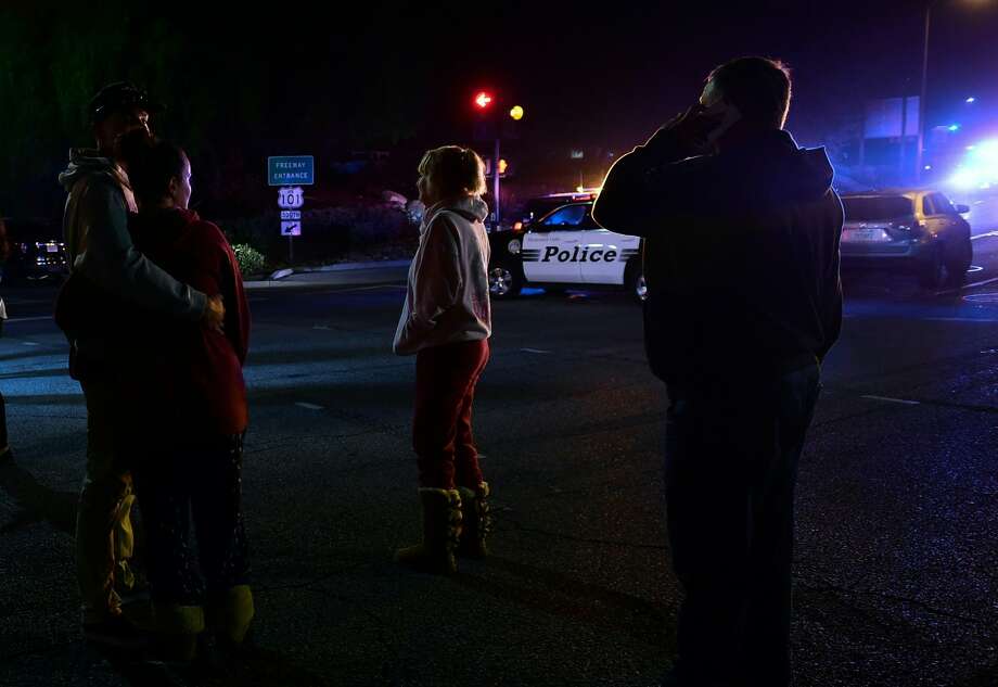 People stand and watch as the scene unfurls from the intersection of US 101 freeway and the Moorpark Rad exit as police vehicles close off the area outside a country music bar and dance hall in Thousand Oaks, west of Los Angeles, where a gunman opened fire late November 7, 2018, killing at least 12 people, US police said. Photo: FREDERIC J. BROWN/AFP/Getty Images