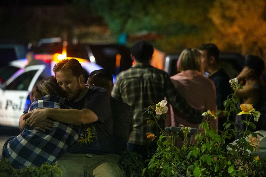 A man speaks with law enforcement personnel as people stand along South Moorpark Road after a gunman opened fire late Wednesday at a Thousand Oaks bar packed with hundreds of people attending a popular event for college students, causing multiple fatalities on November 8, 2018 in Thousand Oaks, California. The gunman burst into the bar around 11:20 p.m., cloaked in all black as he threw smoke bombs and began shooting at targets as young as 18 inside the Borderline Bar & Grill, authorities and witnesses said. Photo: Kent Nishimura/Getty Images