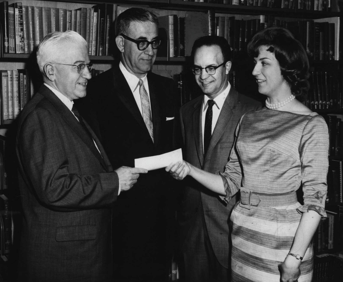 Miss Irene Witke receives a $25 check as an award for excellence in her accounting studies at Russell Sage College Evening Division in Albany, New York. Participating in presentation of the award, which is sponsored by the Capital District Chapter of the Empire State Association of Public Accounts, are, from left, Arthur W Pagano of the chapter's education committee; Eli Werlin, Chairman of the accounting department at the college, and Thomas W Van Valkenburg of the chapter's education committee. May 16, 1964 (Knickerbocker News Staff Photo/Times Union Archive)