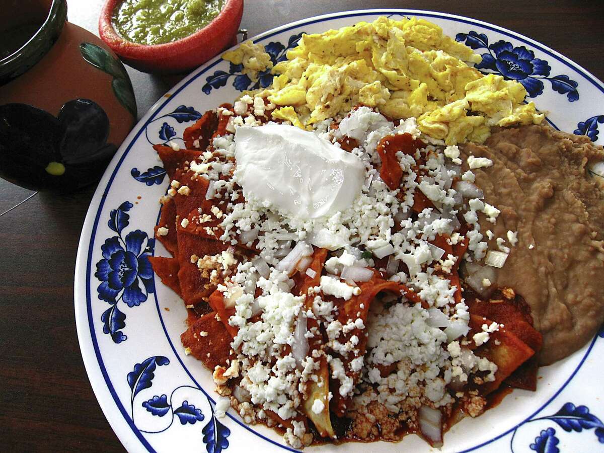 Mama Chuy's chilaquiles with chips, chile sauce, panela cheese and sour cream with sides of scrambled eggs, refried beans and a cup of the cinnamon-sugar coffee called cafe de olla from Las Sabrosas de Guanajuato.
