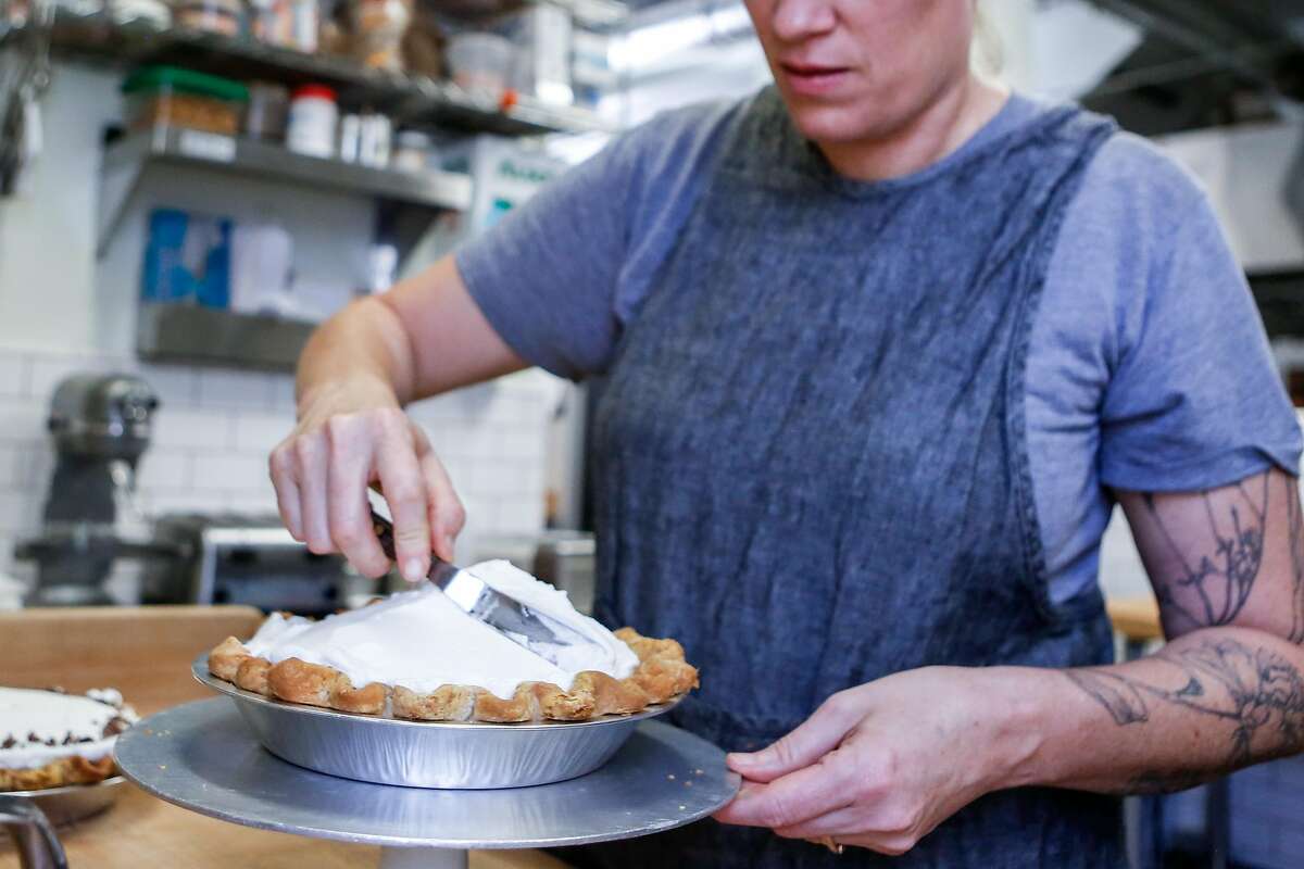 Black Jet Baking Co. owner Gillian Shaw adds whipped cream on top of a finished banana cream pies on Wednesday, November 7, 2018 in San Francisco, Calif.