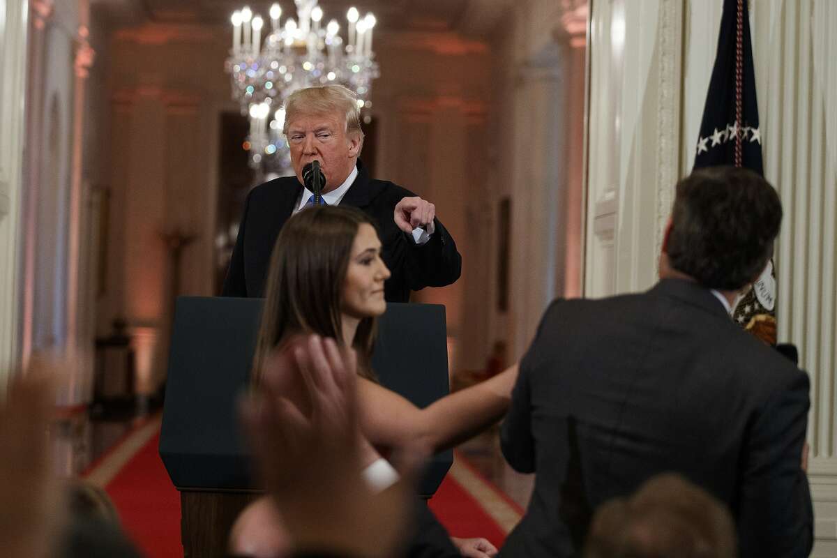 President Donald Trump looks on as a White House aide attempts to take away a microphone from CNN journalist Jim Acosta during a news conference in the East Room of the White House, Wednesday, Nov. 7, 2018, in Washington. (AP Photo/Evan Vucci)